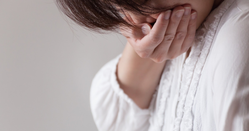 手で口を押さえる女性