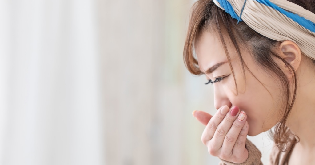 吐き気を我慢する女性