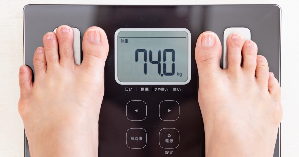 74kgを示す体重計と女性の足