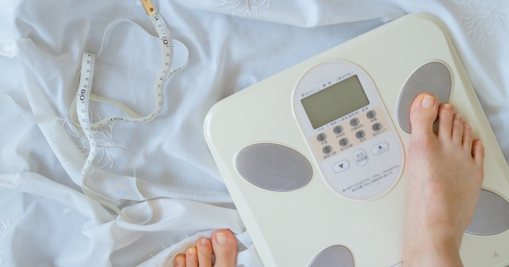 体重計に乗ろうとしている女性