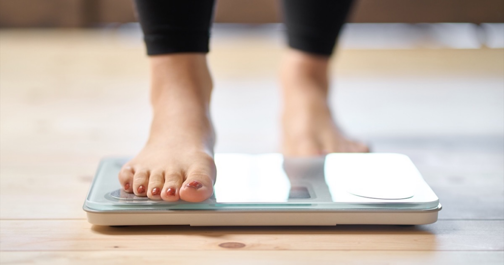 体重計に乗ろうとしている女性