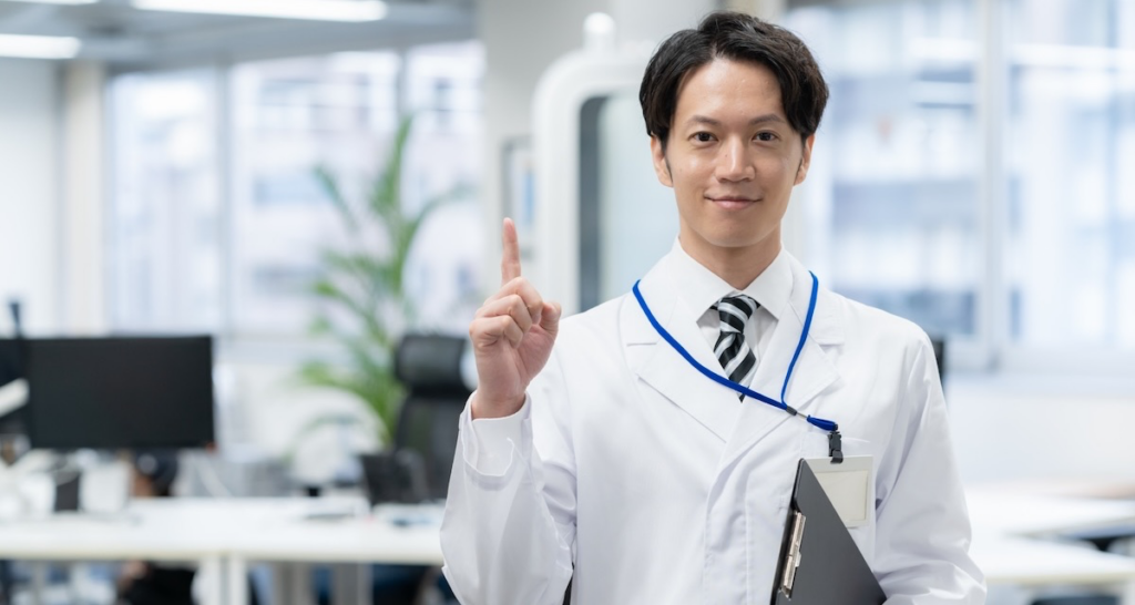 人差し指を立てる若い男性医師