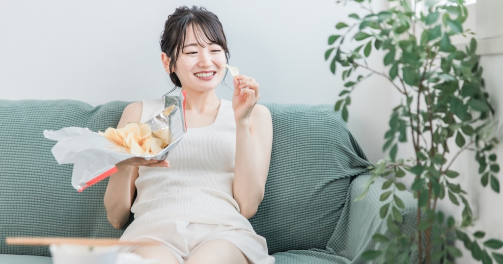 お菓子をむさぼる女性