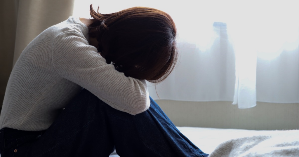 うつむいて落ち込む女性